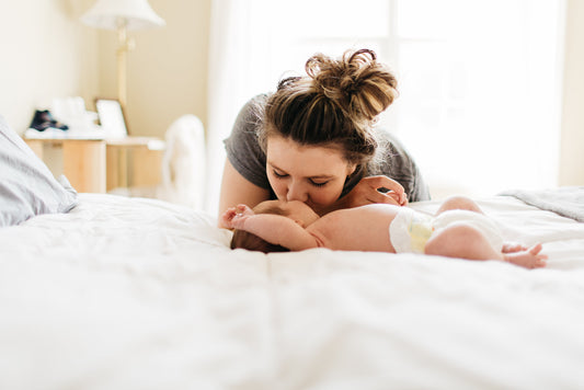 First time mom snuggling with baby deciding if a breast pump is needed.